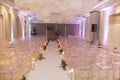 Wedding aisle with empty chairs decorated with candles and flowers and balloons hanging from ceiling Royalty Free Stock Photo