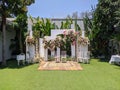 wedding altar with white chairs shot at eye level angle prepared on the beautiful park or garden with flowers decoration Royalty Free Stock Photo