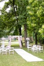 Wedding amazing arch, decorated by roses and chairs in park.