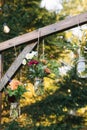 Wedding arbor, with floral arrangements in jars hunged on a wooden beam, with light bulbs Royalty Free Stock Photo