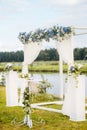 The wedding arch is decorated with blue flowers and white light silk. Summer Wedding Ceremony Royalty Free Stock Photo