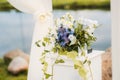 The wedding arch is decorated with blue flowers and white light silk. Summer ceremony. Bridal bouquet Royalty Free Stock Photo