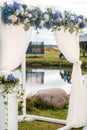 The wedding arch is decorated with blue flowers and white light silk. Summer Wedding Ceremony Royalty Free Stock Photo