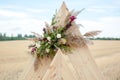 Wedding arch decorated with flower arrangement close up. Floral arrangement consists of eustoma, eucalyptus, pampas, and other