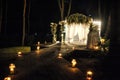 wedding arch decorated with flower compositions and curtains at night