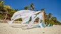 Wedding arch decorated with flowers on the beach near the ocean. Her white and blue canvases fly in the wind. Decorative Royalty Free Stock Photo