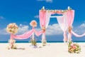 wedding arch decorated with flowers on tropical sand beach, outdoor beach wedding setup Royalty Free Stock Photo