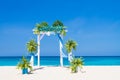 wedding arch decorated with flowers on tropical sand beach, outdoor beach wedding setup Royalty Free Stock Photo