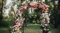 Wedding arch decorated with pink and white flowers in the park