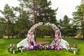 Wedding arch of flowers with torches at an outdoor ceremony