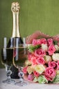 Wedding arrangement of bouquet, champagne, booties and rings at the bottom of the glass Royalty Free Stock Photo