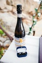 Wedding arrangement on table. Champagne bottle and a box with wedding rings on a rocky beach. Beach wedding concept. Royalty Free Stock Photo