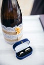 Wedding arrangement on table. Champagne bottle and a box with wedding rings on a white cloth. Royalty Free Stock Photo