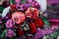 Wedding asymmetrical stylish bouquet with red roses and pomegranate