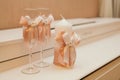 Wedding attributes such as glasses and a candle decorated with pink ribbons with large bows are on the table Royalty Free Stock Photo