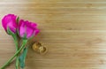 Wedding background concept. Bouquet of pink roses and lovely couple wedding rings on wooden board with copy space Royalty Free Stock Photo