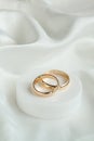 Wedding background with two gold rings on white satin material. Marriage Royalty Free Stock Photo