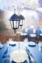 Wedding. Banquet. The chairs and round table for guests, served with cutlery and crockery and covered with a blue Royalty Free Stock Photo