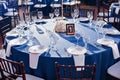 Wedding. Banquet. The chairs and round table for guests, served with cutlery and crockery and covered with a blue Royalty Free Stock Photo