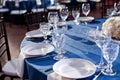 Wedding. Banquet. The chairs and round table for guests, served with cutlery and crockery and covered with a blue Royalty Free Stock Photo