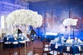 Wedding. Banquet. The chairs and round table for guests, served with cutlery and crockery and covered with a blue Royalty Free Stock Photo