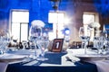 Wedding. Banquet. The chairs and round table for guests, served with cutlery and crockery and covered with a blue Royalty Free Stock Photo