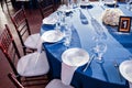 Wedding. Banquet. The chairs and round table for guests, served with cutlery and crockery and covered with a blue Royalty Free Stock Photo