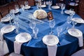 Wedding. Banquet. The chairs and round table for guests, served with cutlery and crockery and covered with a blue Royalty Free Stock Photo