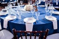 Wedding. Banquet. The chairs and round table for guests, served with cutlery and crockery and covered with a blue Royalty Free Stock Photo