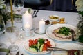 Wedding banquet. The festive table is served with plates with napkins and name cards, glasses and cutlery, and decorated with