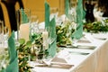 Wedding banquet with floral decoration on table, cards, glasses and cutlery closeup