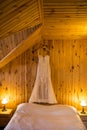 Wedding beige elegance wedding dress on hanger on a wooden wall. Beautiful gown.