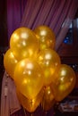 Wedding or birthday photo zone with golden balloons indoors, copy space. Holiday party decoration.