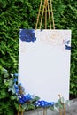 Wedding board, mockup, invitation easel, with space for an inscription, decorated with fresh flowers. Festive decor, copy space.