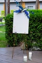 Wedding board, mockup, invitation easel, with space for an inscription, decorated with fresh flowers. Festive decor, copy space.