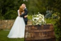 Wedding bouquet on a barrel against the background of the bride and groom at a ceremony in blur Royalty Free Stock Photo