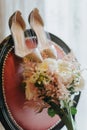 Wedding bouquet and bridal shoes on a chair