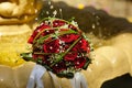 The Wedding Bouquet Of The Bride Of Red Roses Lies In An Old Fountain Under Splashes And Drops Of Water. Royalty Free Stock Photo