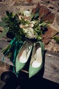 Wedding bouquet for the bride of white and orange flowers and stylish green shoes Royalty Free Stock Photo