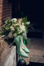 Wedding bouquet for the bride of white and pink flowers and stylish green shoes outdoor Royalty Free Stock Photo
