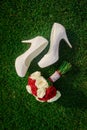 Wedding bouquet and the bride's white shoes on grass Royalty Free Stock Photo