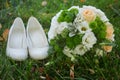 Wedding bouquet and the bride's white shoes on grass Royalty Free Stock Photo