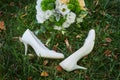 Wedding bouquet and the bride's white shoes on grass Royalty Free Stock Photo