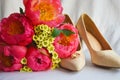 A bridal bouquet of bright pink flowers, beige suede shoes, and wedding rings. Wedding accessories Royalty Free Stock Photo