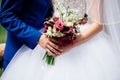 Wedding bouquet of burgundy flowers in bride`s and groom`s hands Royalty Free Stock Photo