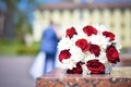 wedding bouquet close-up. In the background, the bride and groom are unfocused. Royalty Free Stock Photo