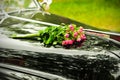 Wedding bouquet on cowl of black car