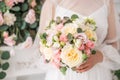 Wedding bouquet with cream and pink roses in the hands of the bride. Delicate flowers close-up. Spring bouquet Royalty Free Stock Photo