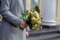 wedding bouquet of delicate white flowers in the hands of the bride on the street. side view.