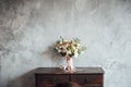 Wedding bouquet on dresser near gray wall with vintage texture Royalty Free Stock Photo